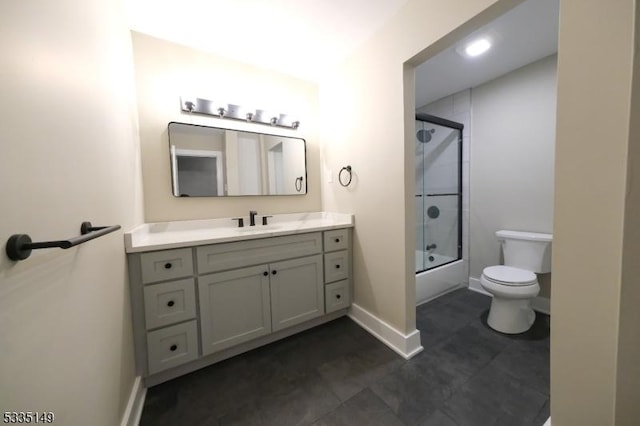 full bathroom featuring bath / shower combo with glass door, vanity, and toilet