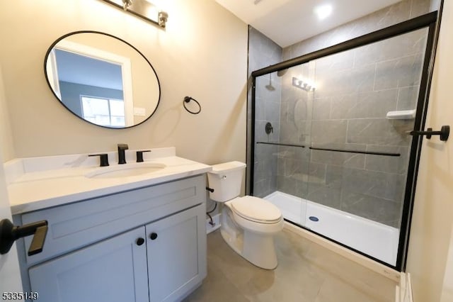 bathroom with vanity, tile patterned flooring, a shower with door, and toilet