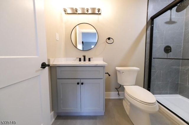 bathroom featuring vanity, tiled shower, and toilet