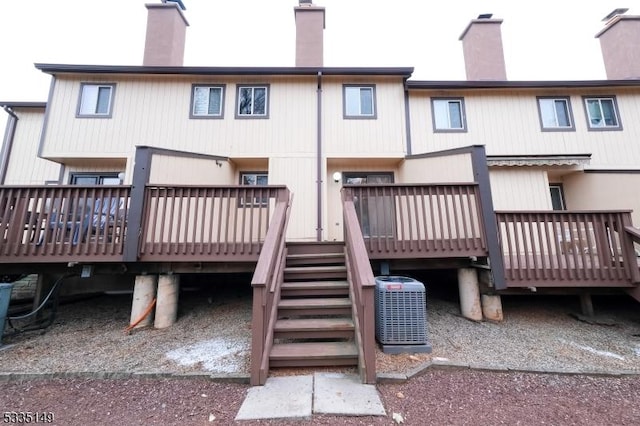 rear view of house with cooling unit and a deck