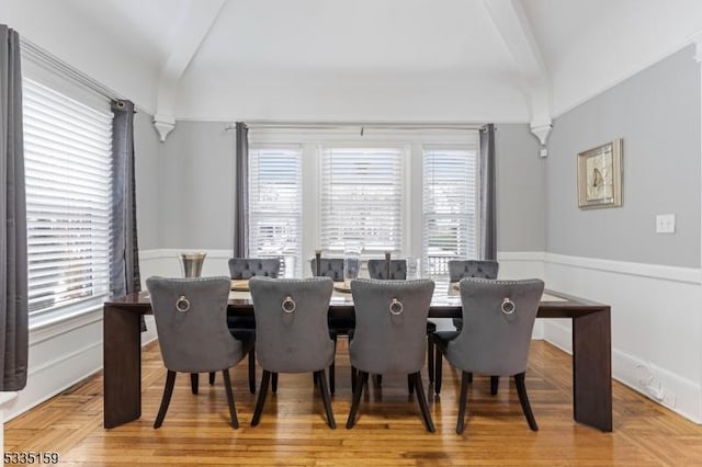 dining space with vaulted ceiling and hardwood / wood-style floors