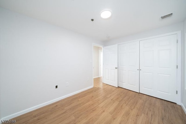 unfurnished bedroom featuring a closet and light wood-type flooring