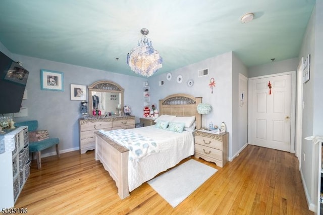 bedroom featuring a chandelier and light wood-type flooring