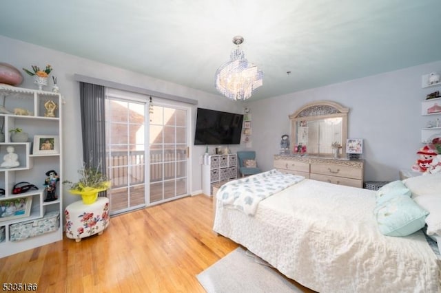 bedroom with access to outside, an inviting chandelier, and light hardwood / wood-style floors