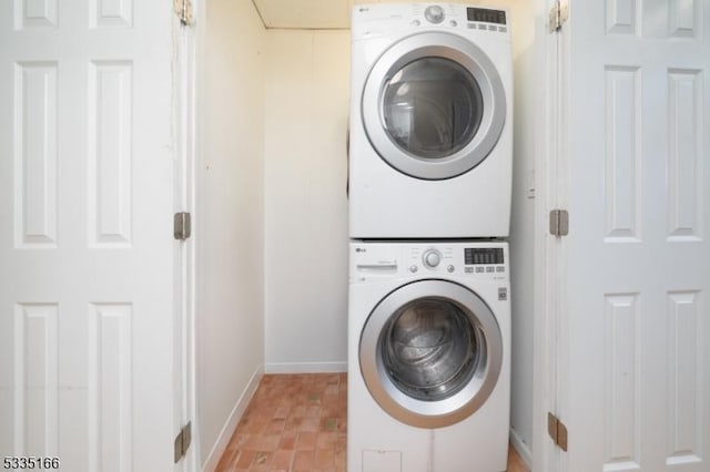 clothes washing area with stacked washing maching and dryer