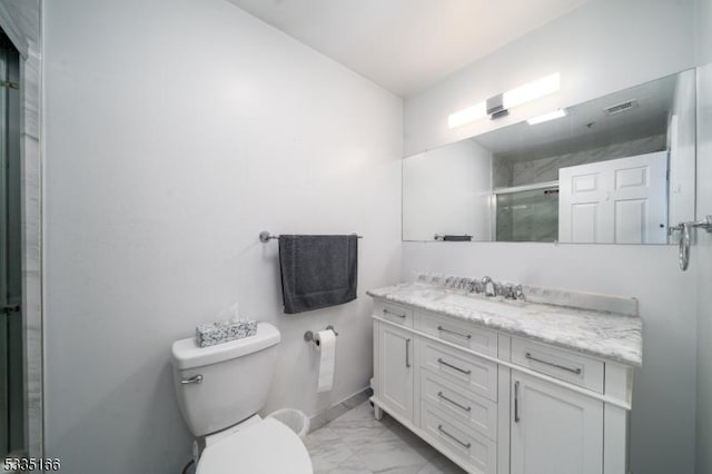 bathroom with vanity, toilet, and a shower with shower door