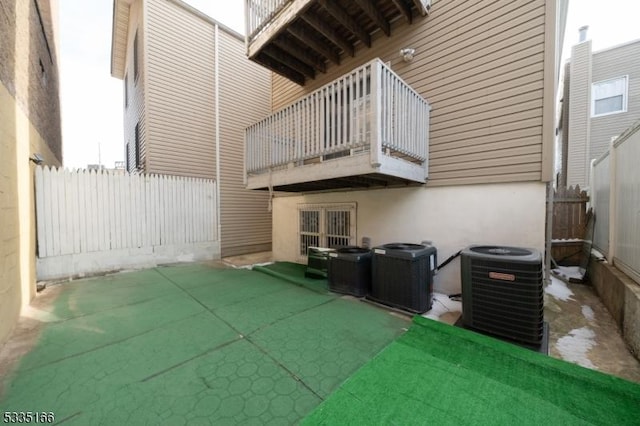 back of property with cooling unit and a balcony