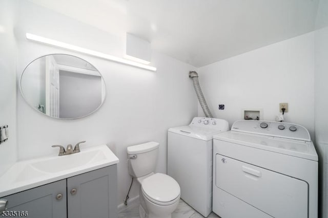 bathroom featuring independent washer and dryer, vanity, and toilet