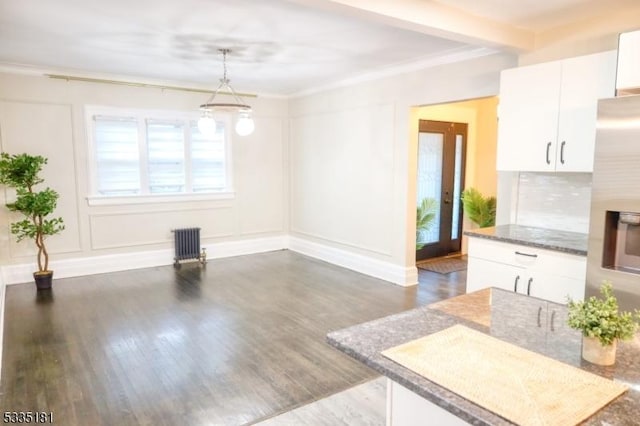 unfurnished dining area featuring ornamental molding, dark hardwood / wood-style floors, and radiator heating unit