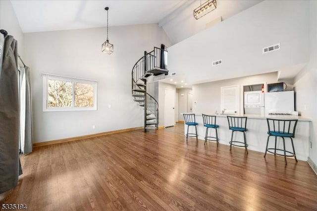 living room featuring high vaulted ceiling and dark hardwood / wood-style flooring