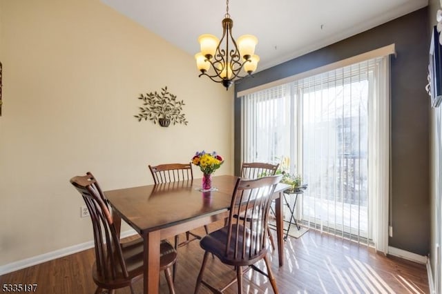 dining area featuring dark hardwood / wood-style floors and an inviting chandelier