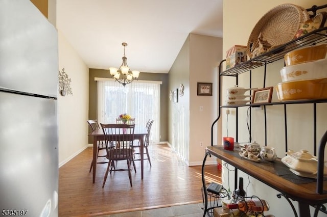 dining area with a notable chandelier and hardwood / wood-style floors