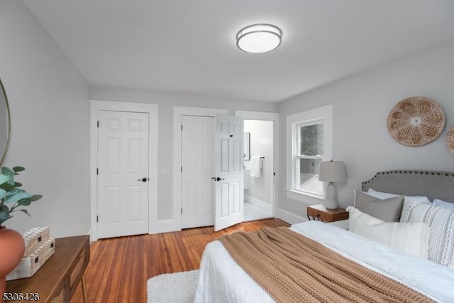 bedroom with wood-type flooring and multiple closets