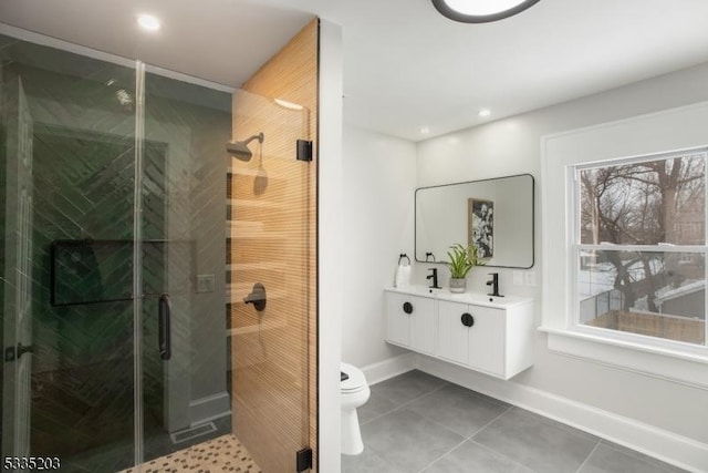 bathroom featuring tile patterned flooring, vanity, a shower with door, and toilet