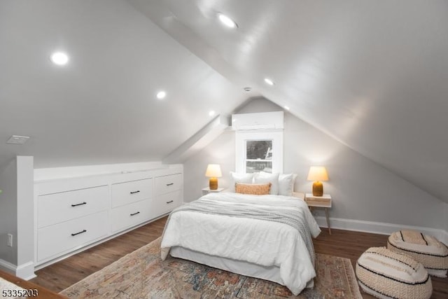 bedroom featuring lofted ceiling, dark wood-type flooring, and a wall mounted air conditioner