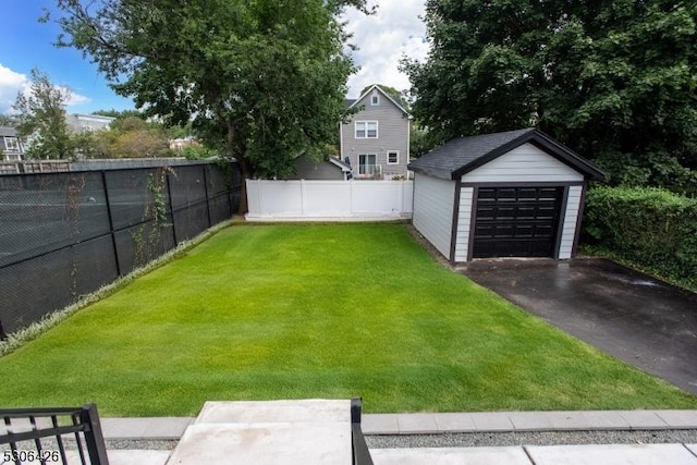 view of yard with a garage and an outbuilding