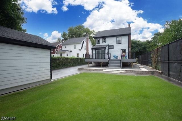 rear view of house featuring a yard and a deck