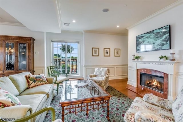 living room featuring crown molding, wood-type flooring, and a fireplace