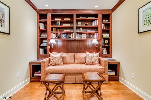 living area with crown molding and light hardwood / wood-style floors