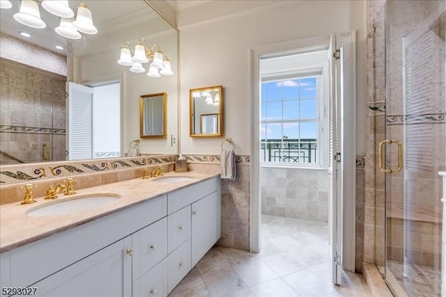 bathroom with tile walls, vanity, crown molding, and a shower with shower door