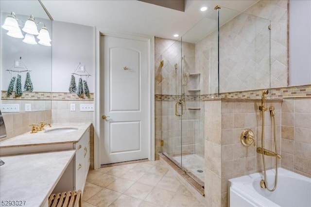 bathroom featuring vanity, tile patterned flooring, shower / bath combination with glass door, and tile walls