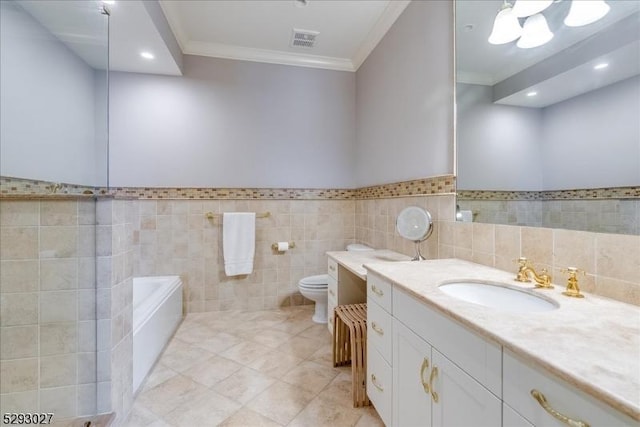 bathroom featuring tile patterned floors, toilet, crown molding, vanity, and a bath