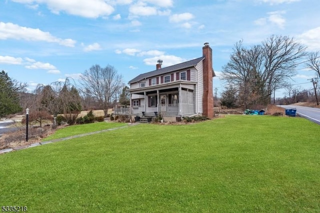 rear view of house with a porch and a yard