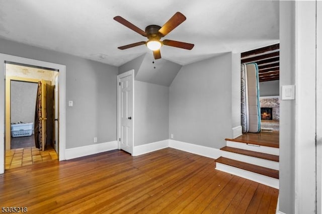 bonus room with hardwood / wood-style flooring, a fireplace, and ceiling fan