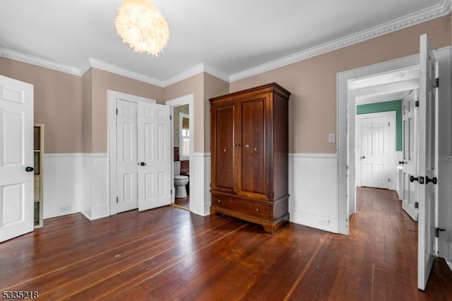 unfurnished bedroom with crown molding, dark hardwood / wood-style floors, and a chandelier