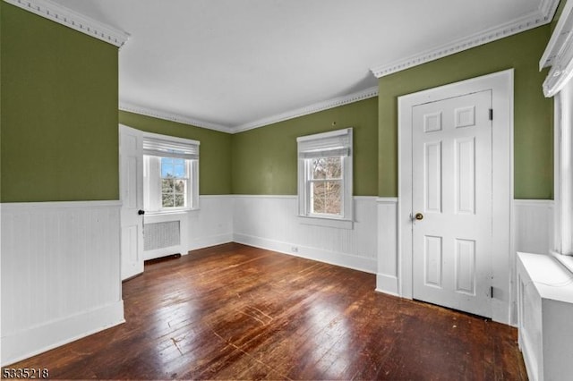 spare room with radiator heating unit, ornamental molding, and dark hardwood / wood-style floors