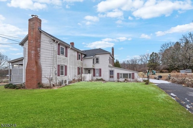 back of property featuring a lawn