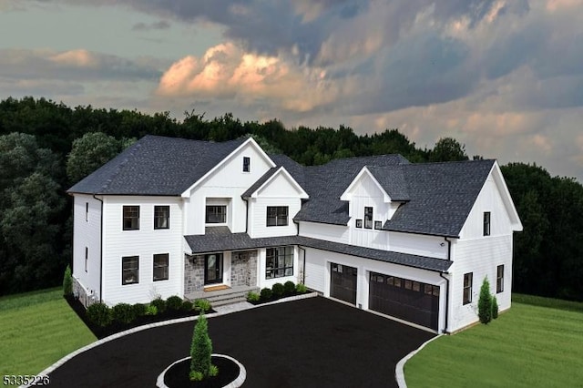 modern inspired farmhouse featuring a shingled roof, a yard, driveway, and an attached garage