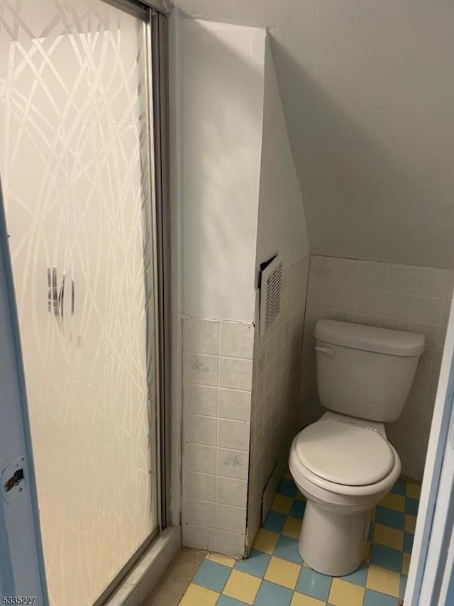 bathroom featuring tile walls and toilet