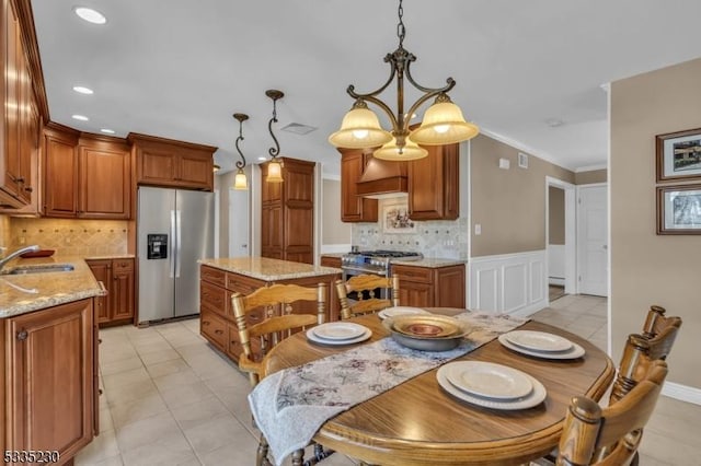 tiled dining area featuring an inviting chandelier, ornamental molding, and sink