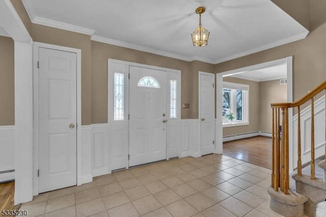 tiled foyer featuring a notable chandelier, crown molding, and baseboard heating