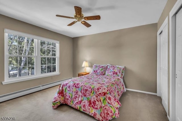 carpeted bedroom with ceiling fan, baseboard heating, and a closet