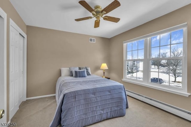 bedroom with light carpet, a baseboard radiator, and ceiling fan