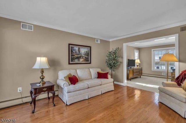 living room featuring crown molding, baseboard heating, and light wood-type flooring