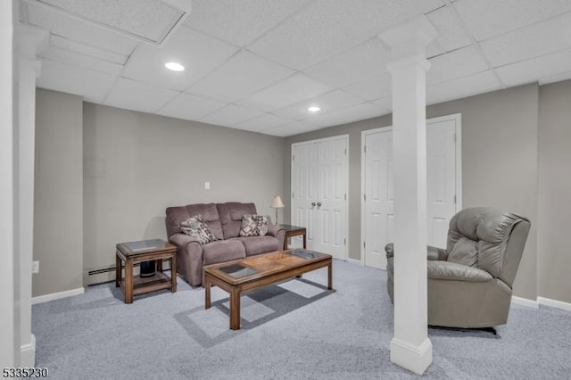 living room with baseboard heating, carpet flooring, and a drop ceiling