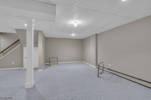 basement with a drop ceiling, carpet flooring, and baseboard heating