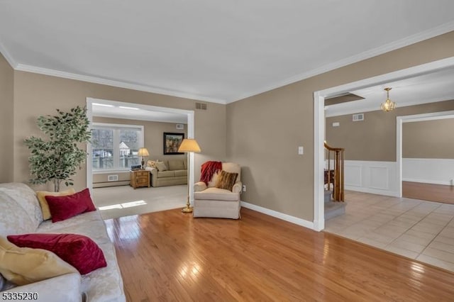 living room with ornamental molding and light hardwood / wood-style flooring