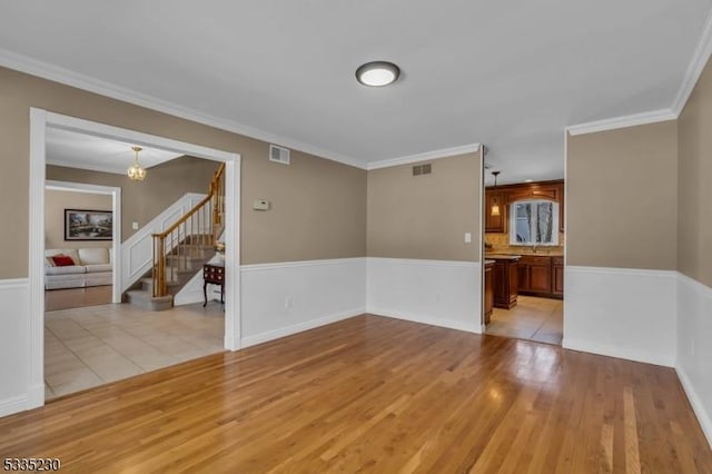 empty room featuring crown molding and light wood-type flooring