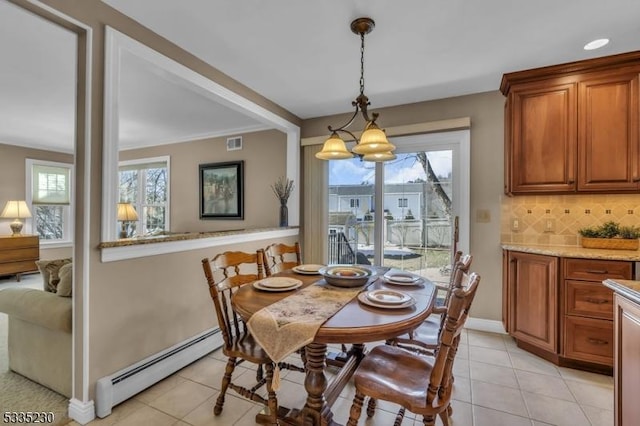 tiled dining room with a baseboard heating unit