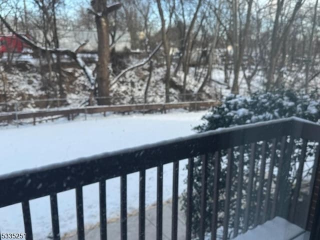 view of snow covered back of property