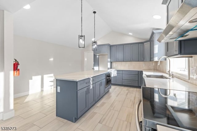 kitchen featuring pendant lighting, sink, island exhaust hood, range with electric stovetop, and a kitchen island