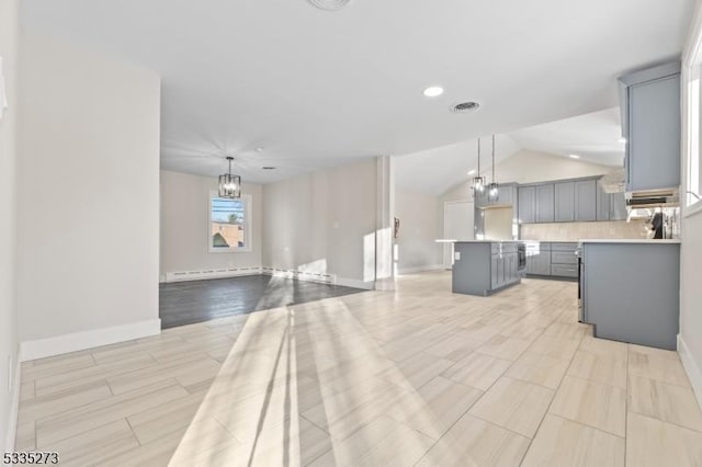 kitchen featuring pendant lighting, gray cabinetry, backsplash, an inviting chandelier, and a kitchen island