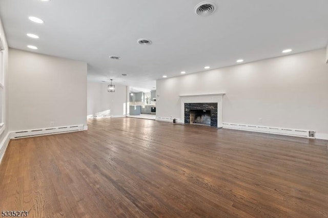 unfurnished living room featuring a baseboard radiator, a premium fireplace, and dark hardwood / wood-style flooring