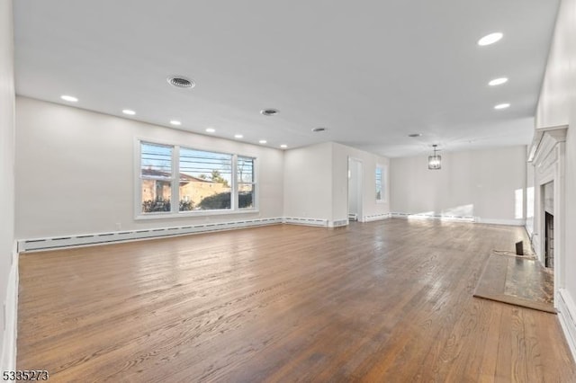 unfurnished living room with a baseboard radiator and light hardwood / wood-style floors