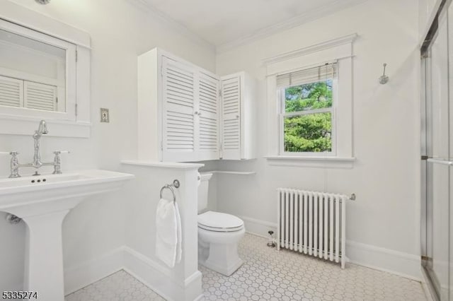 bathroom featuring ornamental molding, radiator heating unit, and toilet