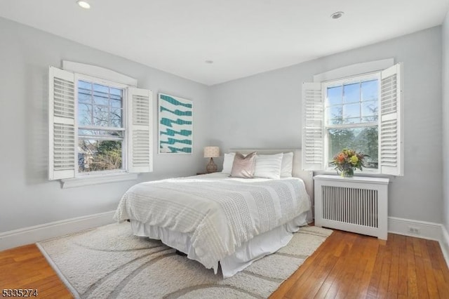 bedroom featuring radiator heating unit and wood-type flooring